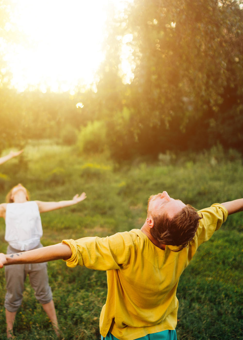 Wiosna w M1 Zabrze. Ludzie z rozłożonymi rękami na trawie.
